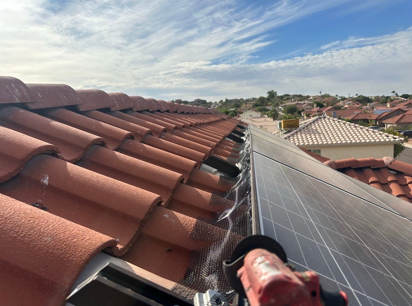Solar panel pigeon mesh being secured along tile roof edges